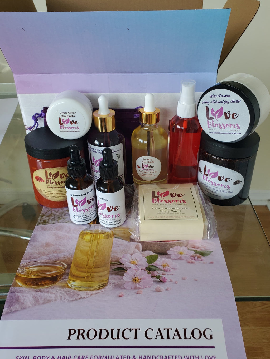An open cardboard Brand Ambassador Starter Kit box filled with assorted hair, skin, and body care products from Love Blossoms Essentials.
