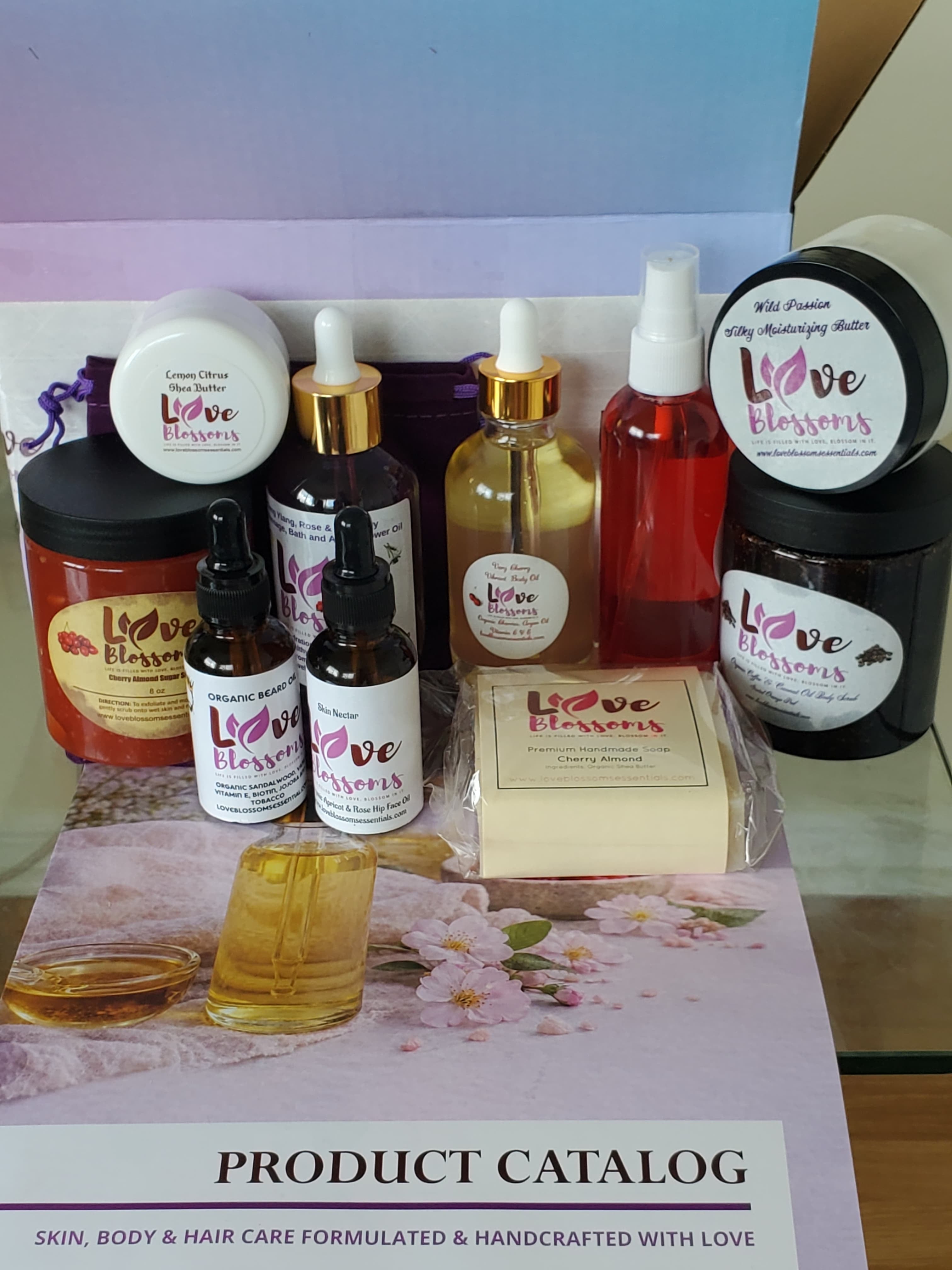 A collection of Love Blossoms Essentials skincare and body care products arranged on a display for the Brand Ambassador Starter Kit.
