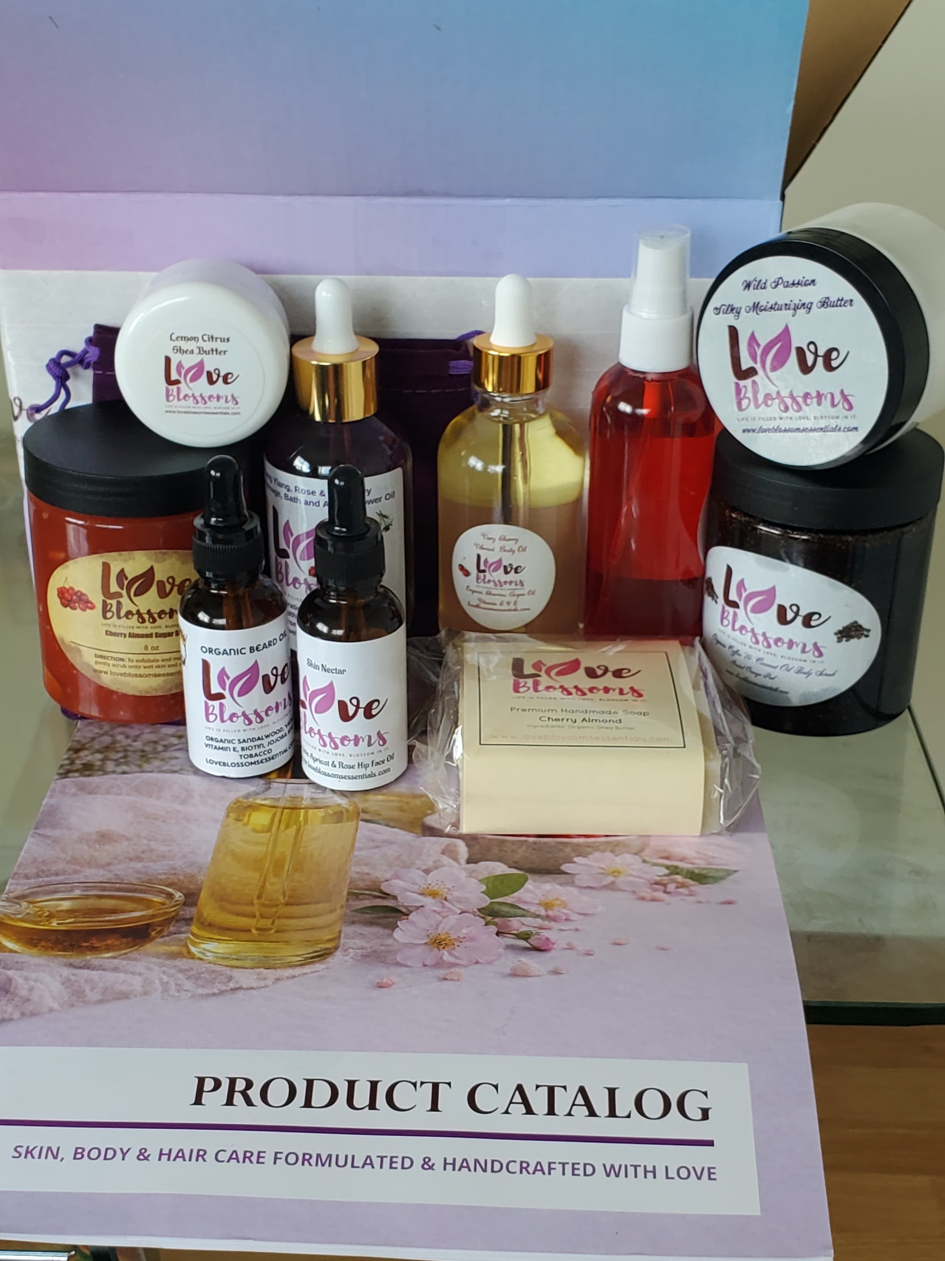 A collection of handcrafted skincare and body care products from Love Blossoms Essentials Brand Ambassador Starter Kit  arranged on a product catalog. 
